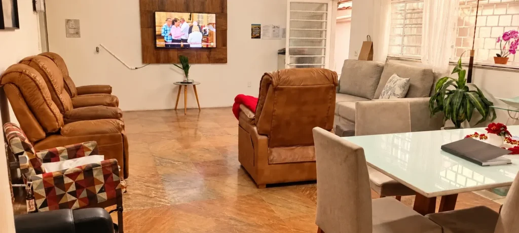 Foto de um espaço social com 4 poltronas, uma mesa de jantar e um sofá