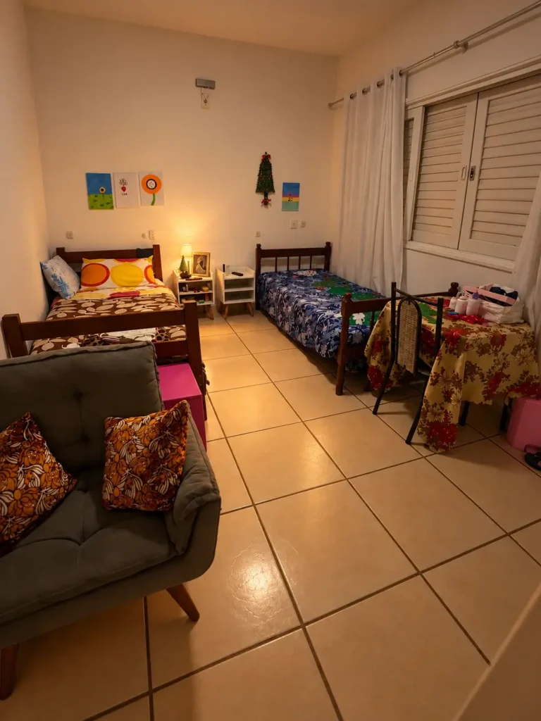Foto de um quarto aconchegante com duas camas, uma mesa e uma poltrona